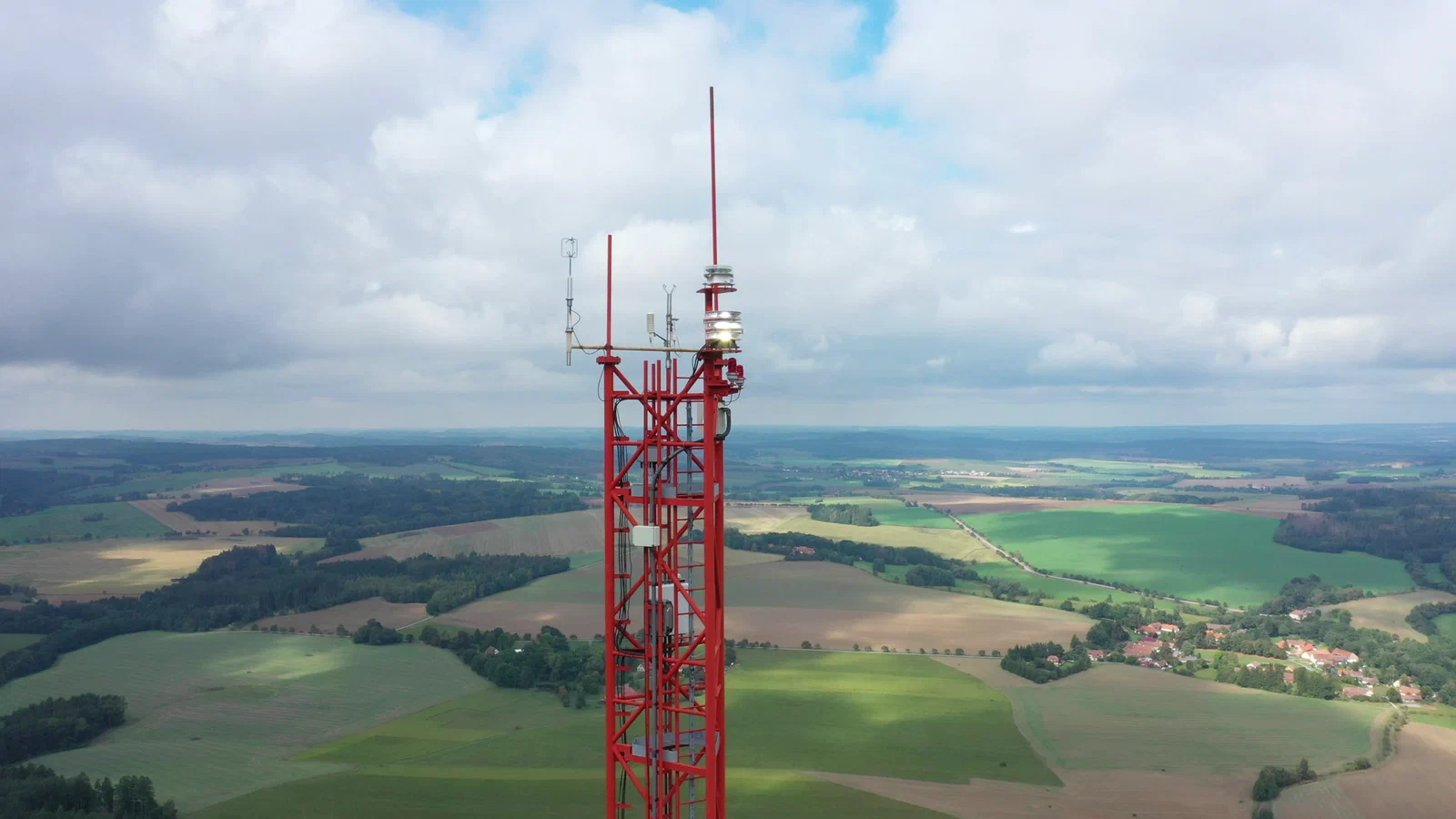 FAA-compliant red obstruction beacon on a communications tower at dusk