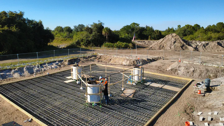 Drone view of the rebar mat, anchor-bolt templates, and crew on a 4-carrier tower foundation pour for Streamline Internet in Hendry County, Florida