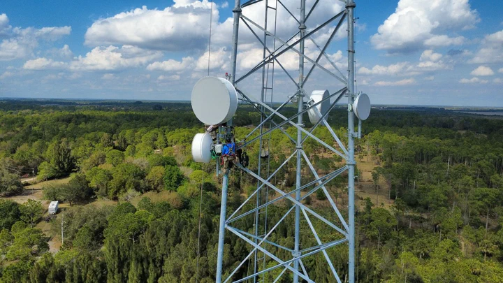 Vertical Axis crew aligning microwave dishes near the top of a Streamline Internet tower in Hendry County, Florida