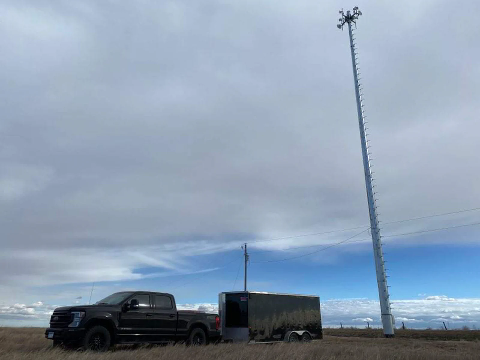 Completed direct embedment monopole on a prairie site with Vertical Axis truck and trailer staged at the pad