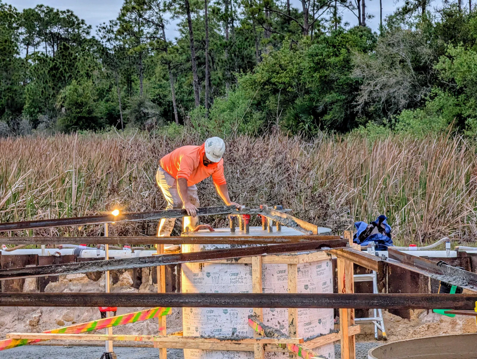 Rebar cage being placed in a drilled-pier foundation excavation on a new tower site