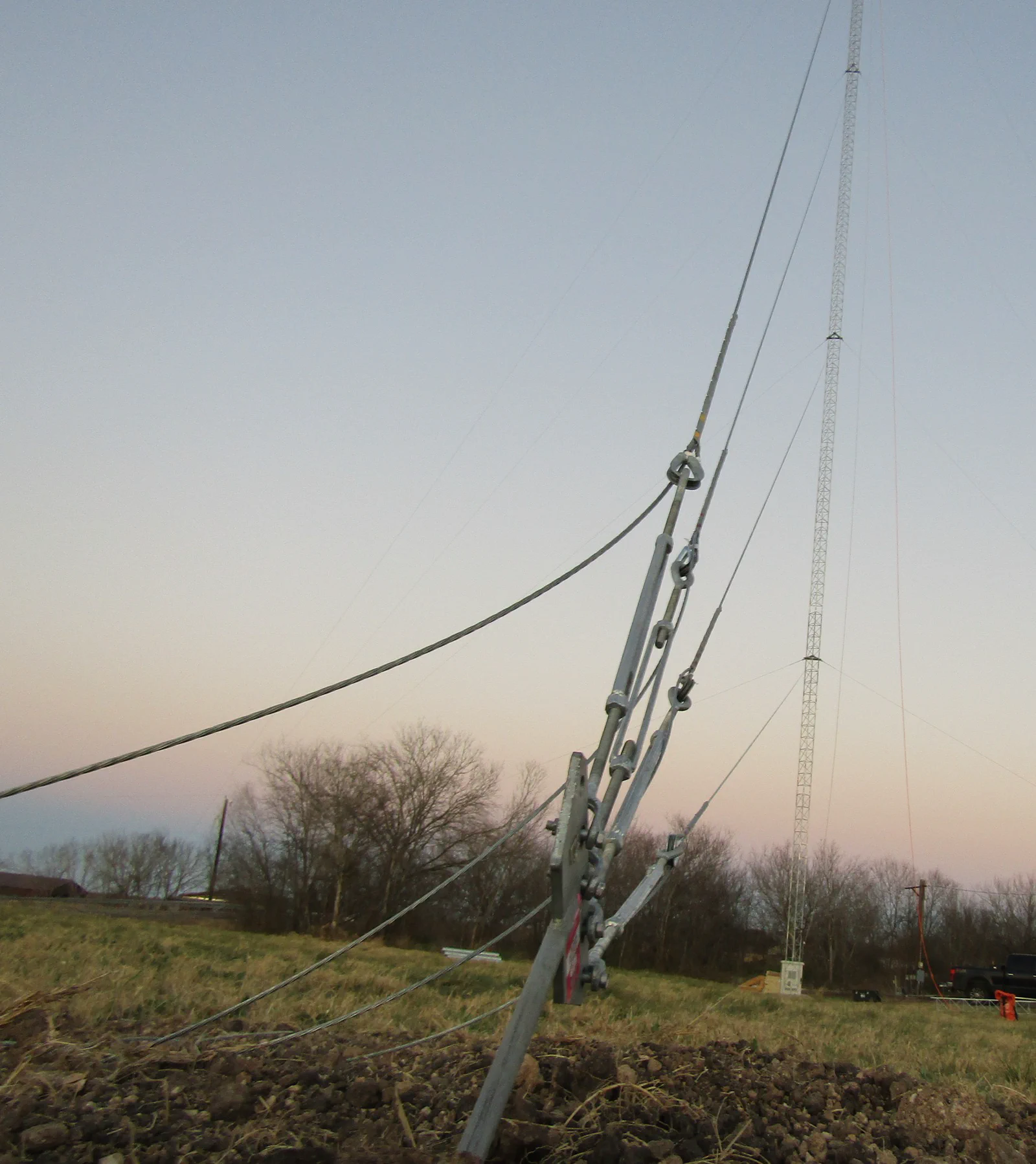 Climber measuring plumb and guy tension on a guyed tower